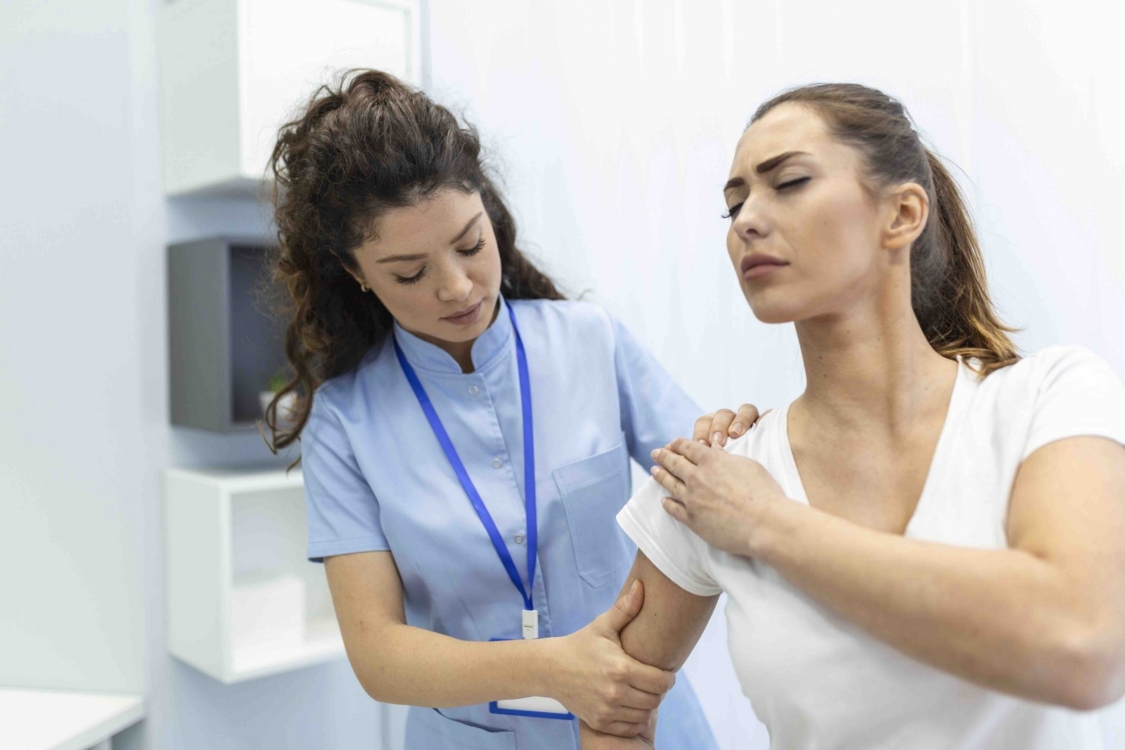 Woman doctor osteopath in medical uniform fixing woman patients shoulder and back joints in manual therapy clinic during visit. Professional osteopath during work with patient concept Top Shoulder Surgery Clinic in London